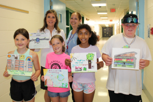  Students holding their winning artwork with teachers